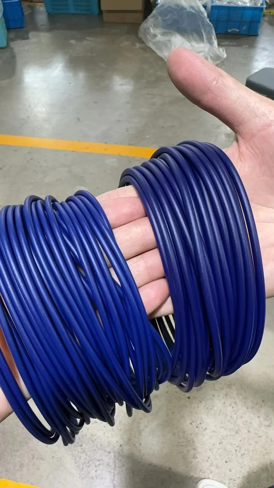 Blue PTFE-coated O-rings held in a hand after coating