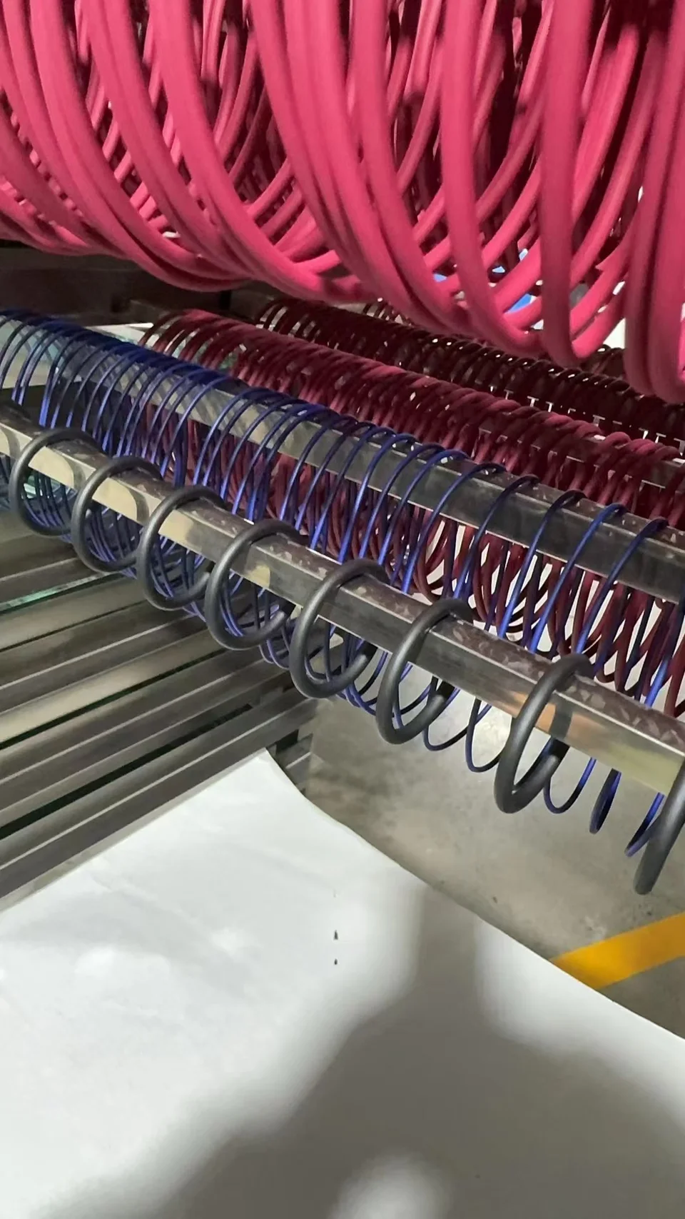 Coated O-rings suspended on racks during the drying stage