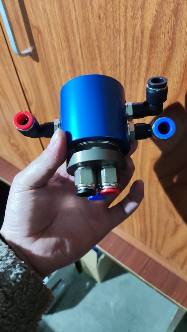 Assembled pneumatic rotary union with a blue anodized stator housing and multiple air fittings