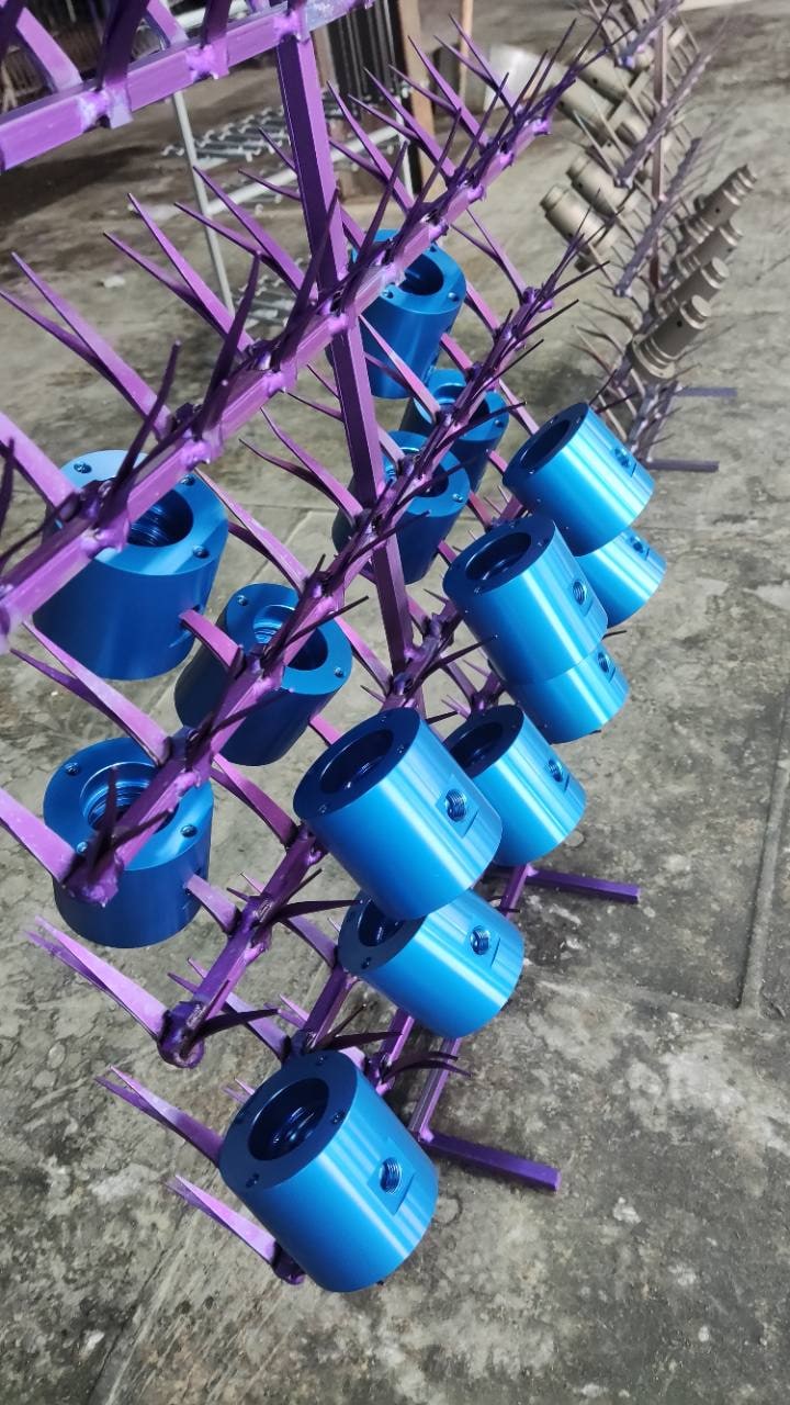 Batch of blue anodized rotary-union stator housings hanging on a production rack